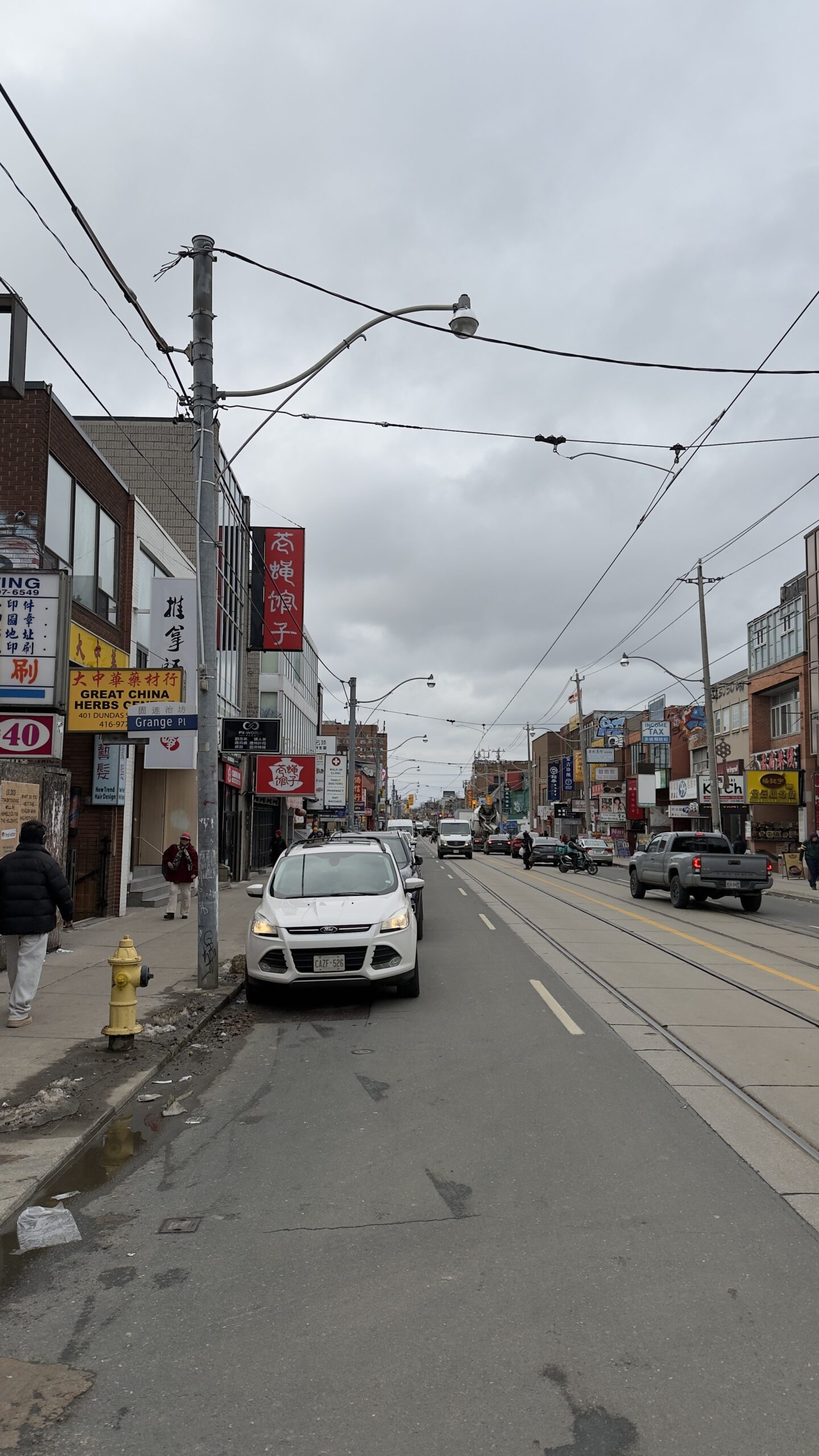 Toronto Sightseeing zu Fuß – 15 Kilometer quer durch die Stadt Straße in Torontos Chinatown mit chinesischen Schildern und Oberleitungen